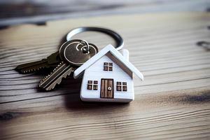 verklig egendom begrepp - nyckel ringa och nycklar på vit trä- bakgrund foto
