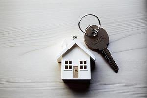 verklig egendom begrepp - nyckel ringa och nycklar på vit trä- bakgrund foto