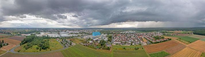 panorama- Drönare bild av de sydlig hessian distrikt stad av gross-gerau under ett närmar sig åskväder och tung regn foto