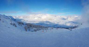 panorama- se över snöig åka skidor tillflykt i österrikiska alps under dagtid foto