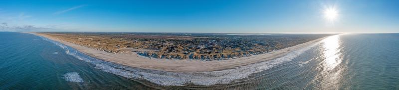 Drönare panorama över vägers strand i Danmark med solsken och snö foto