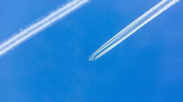 två motordriven flygplan under flyg i hög höjd över havet med kondensation spår foto