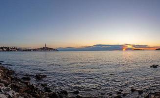 se till de historisk Centrum av rovinj under solnedgång med vatten reflektioner och trevlig moln formationer foto