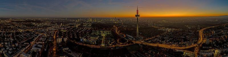 panorama- Drönare bild av de frankfurt horisont med tv torn i de kväll under en färgrik och imponerande solnedgång foto