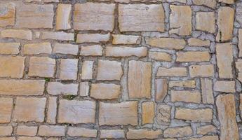 närbild av ett gammal naturlig sten vägg med typisk textur foto