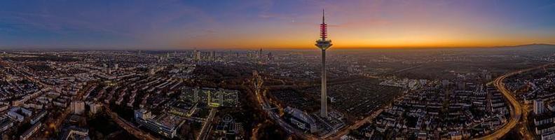 panorama- Drönare bild av de frankfurt horisont med tv torn i de kväll under en färgrik och imponerande solnedgång foto