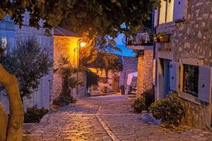 scen av en kullerstensbelagd gata i de historisk Centrum av rovinj i kroatien under natt foto