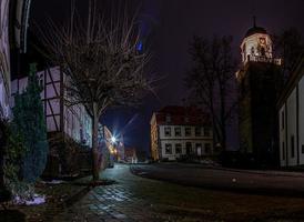 natt scen av ett gammal tysk stad med dubbverk hus och kullerstensbelagda gata i våt väder foto