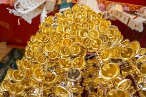 se upp se av av många små gyllene klockorna var hängd i en grupp i thai tempel. foto