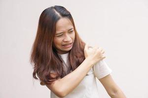 asiatisk kvinna har axel smärta foto