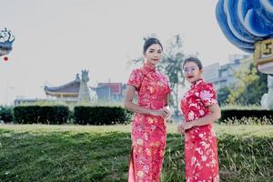 Lycklig kinesisk ny år. asiatisk kvinna bär traditionell Cheongsam qipao klänning. foto