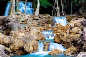 Fantastisk färgrik vattenfall i nationell parkera skog under vår, vackert djup skog i thailand, teknik lång exponering, under semester och koppla av tid. foto