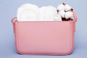 tamponger, hygienisk trosa liners, feminin sanitär dynor i en kvinnors rosa kosmetisk väska foto