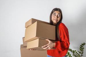 ung kvinna bara rörd i in i ny tömma lägenhet uppackning och rengöring - omlokalisering. ung flicka bärande kartong lådor på ny hem.flyttar hus. foto