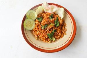mie tek tek eller friterad nudel tillverkad med ägg spaghetti med kyckling, kål, senap gröna, köttbullar, krypterade ägg. indonesiska mat foto