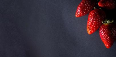mogen jordgubb bär på en mörk bakgrund. Plats för din text foto