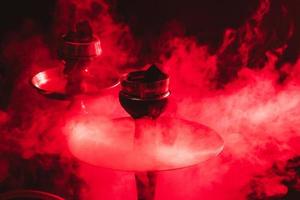 vattenpipa skål, shisha och kol närbild på en rökig svart bakgrund med färgad belysning foto