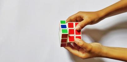 jakarta, januari 2023. mänsklig händer spelar en rubiks kub foto