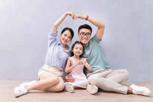 ung asiatisk familj Sammanträde på de golv foto