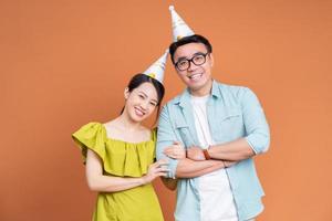ung asiatisk par innehav födelsedag kaka på bakgrund foto