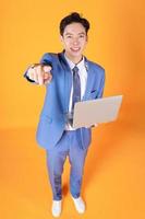 bild av ung asiatisk affärsman använder sig av bärbar dator på bakgrund foto