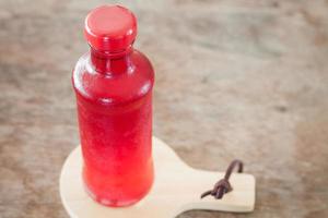 närbild av en flaska röd juice foto