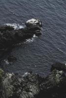 Flygfoto över kustens stenar och vatten foto