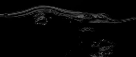 flytande yta linje mellan under vattnet och ovan vatten med svart bakgrund. foto