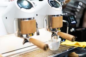 Barista gör kaffe i en kaffe maskin foto