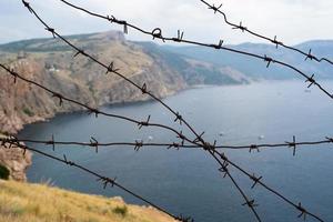 militär gräns av hullingförsedda tråd på hav i de bergen foto