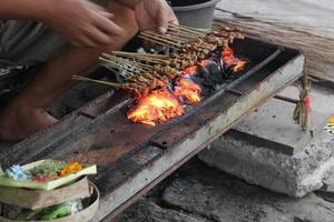 Foto av en fläsk satay framställning bearbeta i bali.