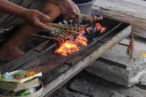 Foto av en fläsk satay framställning bearbeta i bali.