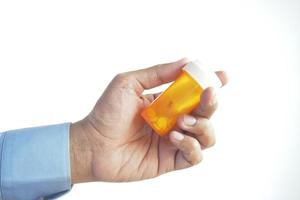 män innehav en medicinsk piller behållare isolerat på vit foto