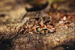 skön bröllop ringar lögn på trä- yta mot bakgrund. hjärtans dag. bröllop ringar. bröllop dag detaljer foto