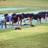 New Delhi, Indien, 18 juni 2022 - gruppyoga träningsklass surya namaskar för människor i olika åldrar i lodhi garden, internationella yogadagen, stor grupp vuxna som deltar i en yogaklass i parken foto