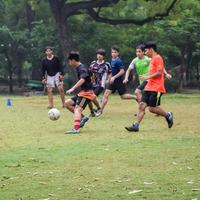 ny delhi, Indien - juli 01 2018 -fotbollsspelare av lokal- fotboll team under spel i regional derby mästerskap på en dålig fotboll tonhöjd. varm ögonblick av fotboll match på gräs grön fält av de stadion foto