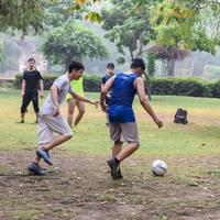 ny delhi, Indien - juli 01 2018 -fotbollsspelare av lokal- fotboll team under spel i regional derby mästerskap på en dålig fotboll tonhöjd. varm ögonblick av fotboll match på gräs grön fält av de stadion foto