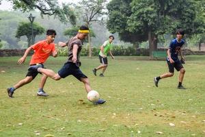 ny delhi, Indien - juli 01 2018 -fotbollsspelare av lokal- fotboll team under spel i regional derby mästerskap på en dålig fotboll tonhöjd. varm ögonblick av fotboll match på gräs grön fält av de stadion foto