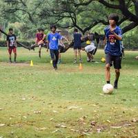 ny delhi, Indien - juli 01 2018 -fotbollsspelare av lokal- fotboll team under spel i regional derby mästerskap på en dålig fotboll tonhöjd. varm ögonblick av fotboll match på gräs grön fält av de stadion foto