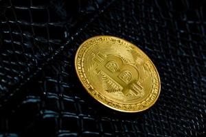 gyllene bitcoins på svart läder bakgrund foto