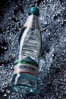 krasnoyarsk, ryssland - oktober 21, 2022 en flaska av borjomi mineral vatten lögner på krossad is. foto