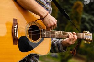 ung musiker spelar akustisk gitarr stänga upp foto