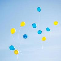 blå och gul ballonger i de stad festival på blå himmel bakgrund foto
