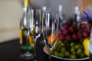 champagne i en hotell rum, is hink, glasögon och frukt på en tallrik - smekmånad begrepp foto