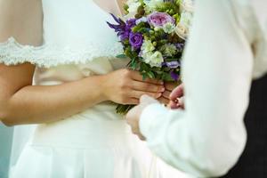 de brud och brudgum utbyta ringar under en bröllop ceremoni, en bröllop i de sommar trädgård foto
