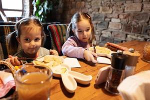 familj har en måltid tillsammans i äkta ukrainska restaurang. flickor barn äta dumplings. foto