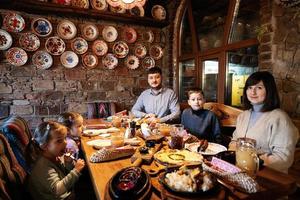 familj har en måltid tillsammans i äkta ukrainska restaurang. foto