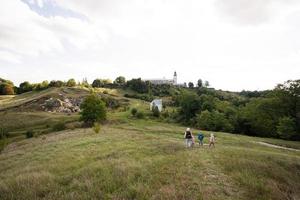 barn utforska natur. barn ha på sig ryggsäck vandring med mor i kulle. pidkamin, ukraina. foto