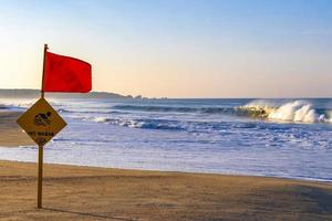 röd flagga simning förbjuden hög vågor i puerto escondido Mexiko. foto