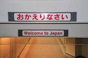 tecken ordspråk Välkommen till japan i engelsk och japansk i narita flygplats i tokyo japan foto